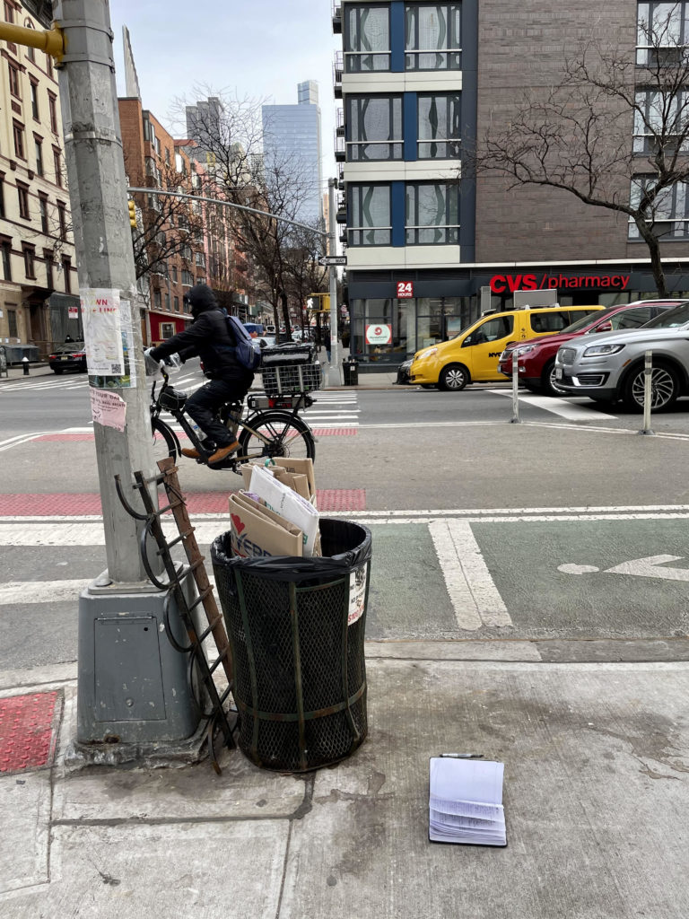 NYC biker riding past open notebook