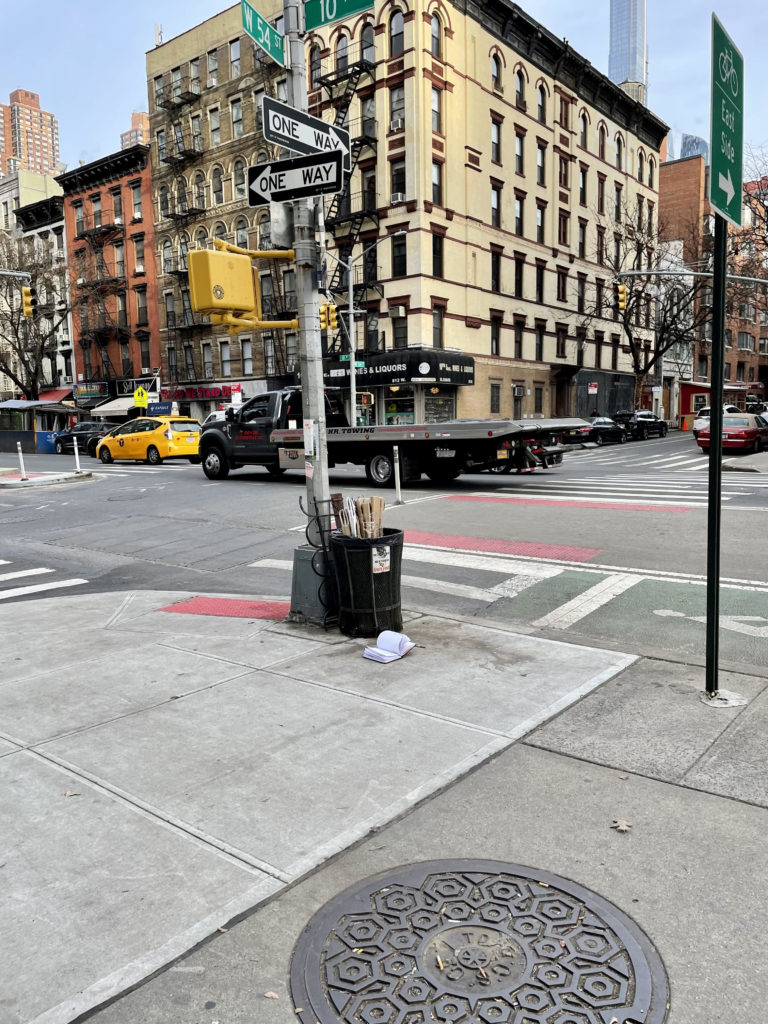 open notebook next to NYC trash can