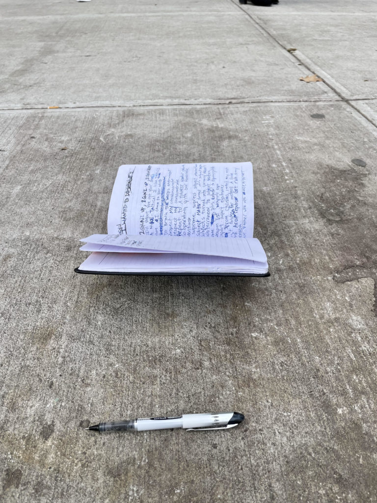 pen and open notebook on NYC sidewalk