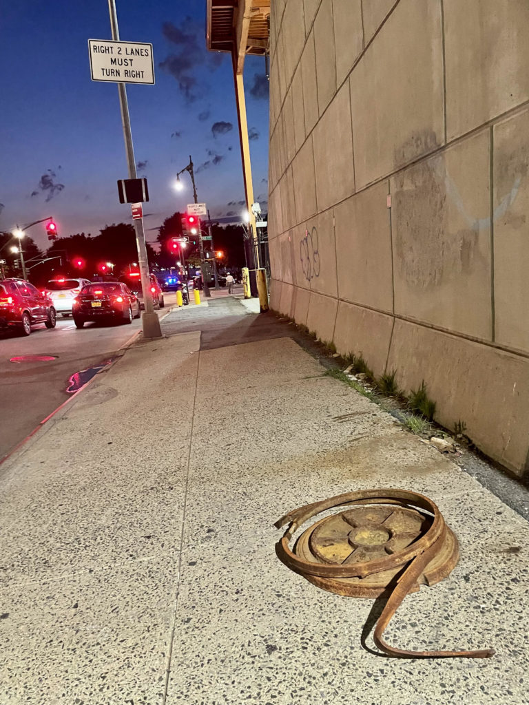 manhole cover at night, New York City.