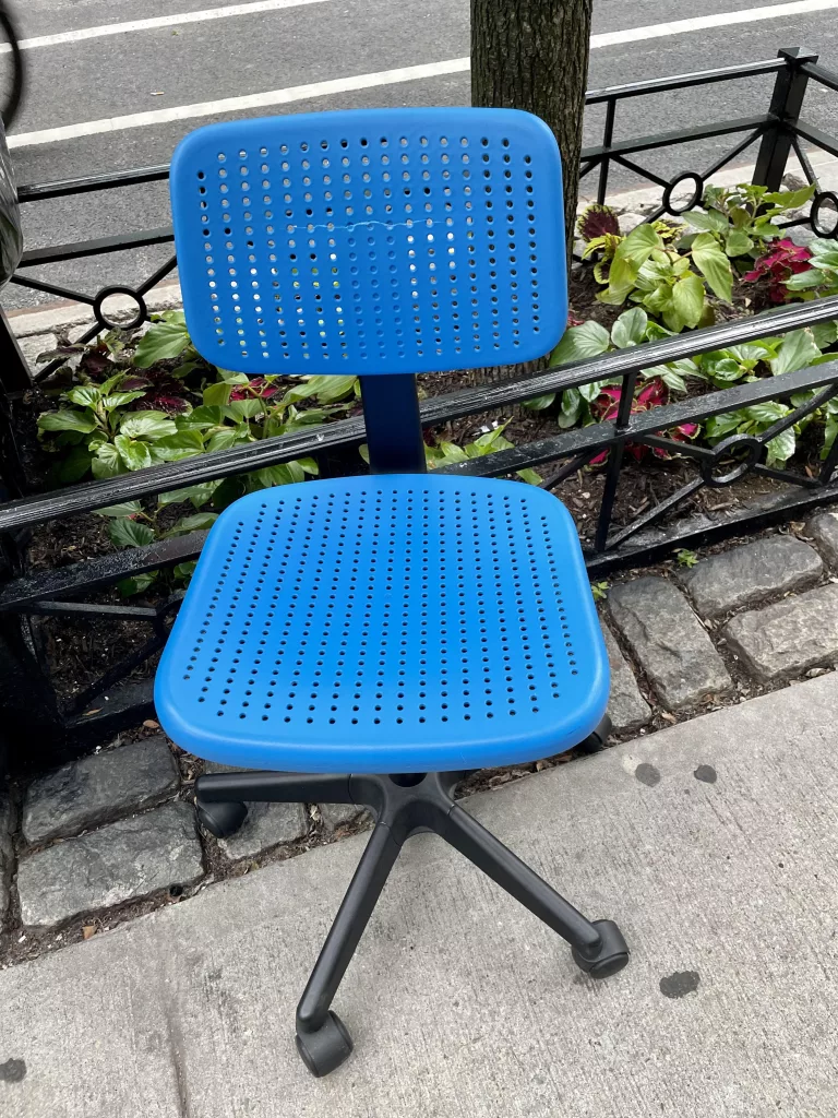 Discarded blue chair in New York City.