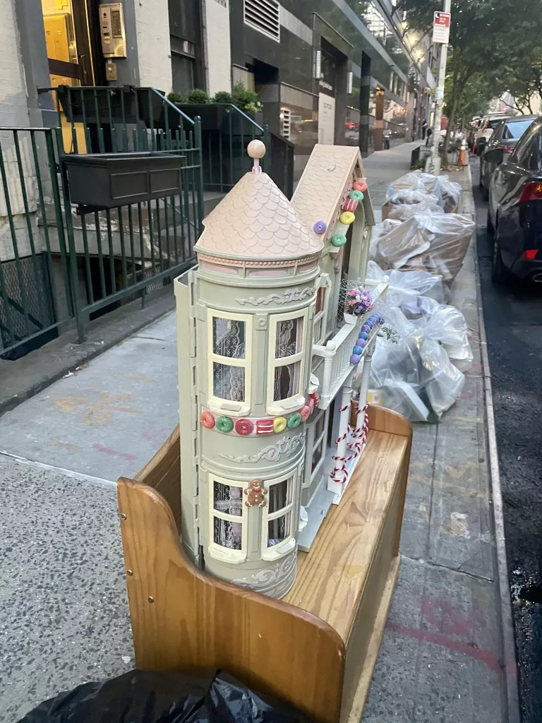 Abandoned doll house on a New York City sidewalk.