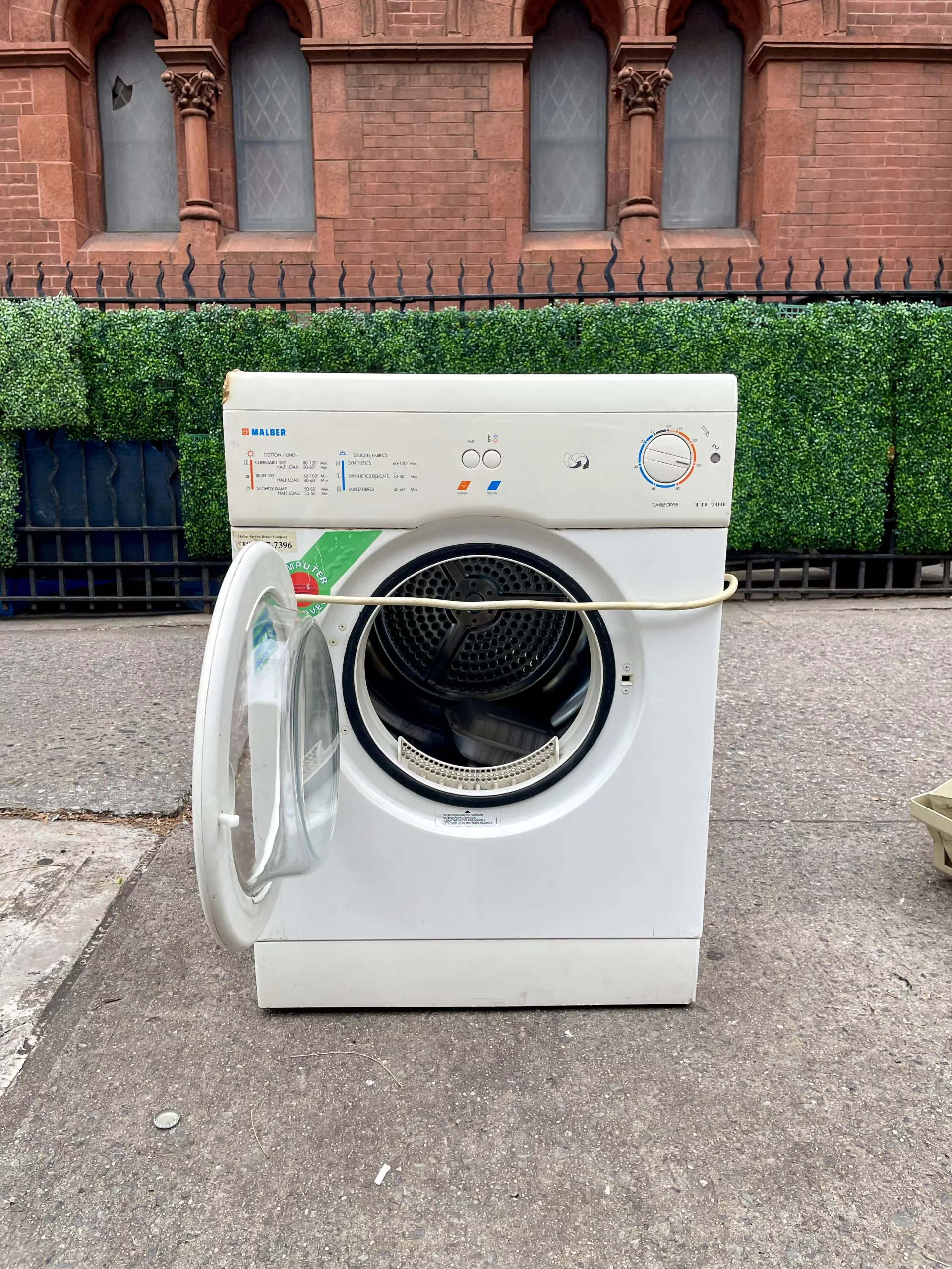 Abandoned washing machine on a New York City sidewalk.